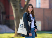 Photo of student Emma Broggi with a tote bag she designed