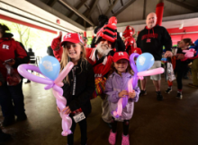Kids holding balloons wearing Rutgers hats