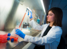 Rutgers researcher collecting a sample from a tube.